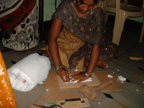 A woman sits on the floor and works
