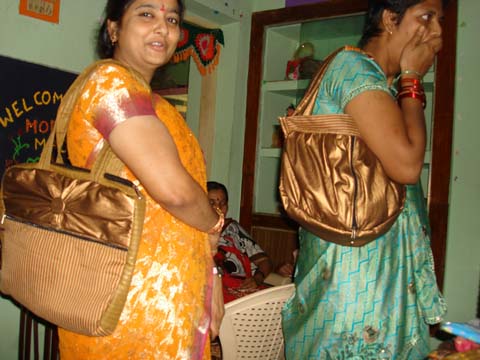 Students of the sewing schools proudly present handbags and embroidered saris of their own design.